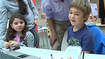 看到孩子在一个教育研讨会在剑桥科学中心项目乐高Mindstorm NXT机器人使用仿真软件来执行一系列的任务。金宝app